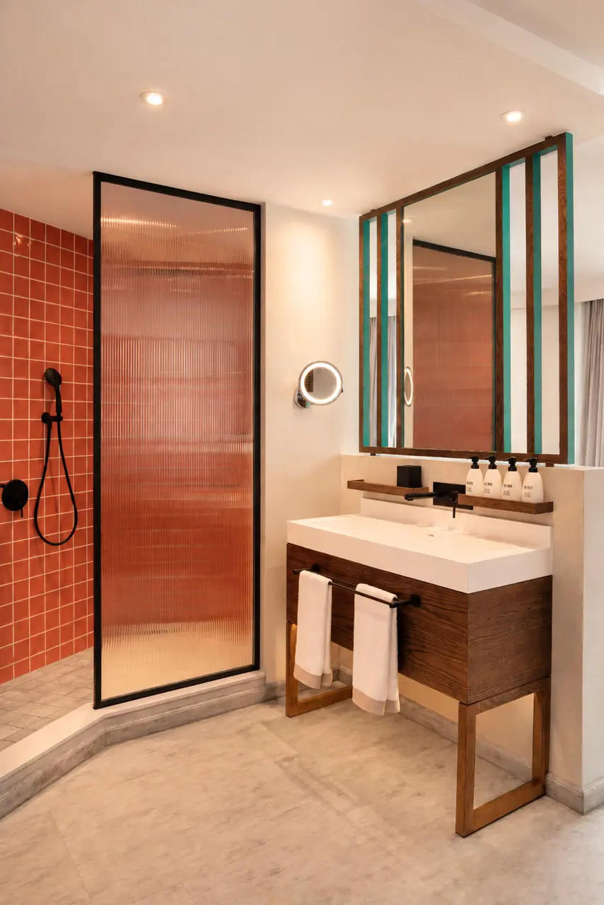 Contemporary hotel bathroom with a walk-in shower, vanity, and modern design details.