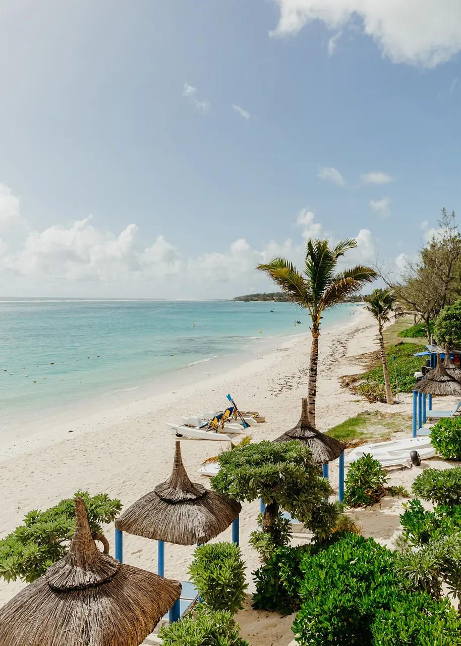 Vue sur la plage de sable blanc du SALT of Palmar, ses palmiers et son lagon cristallin sur la côte est de l'île Maurice.