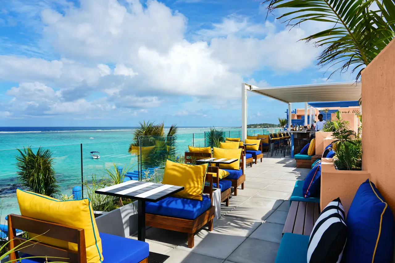 Bar sur le toit avec vue panoramique sur le lagon et confortables salons en plein air.