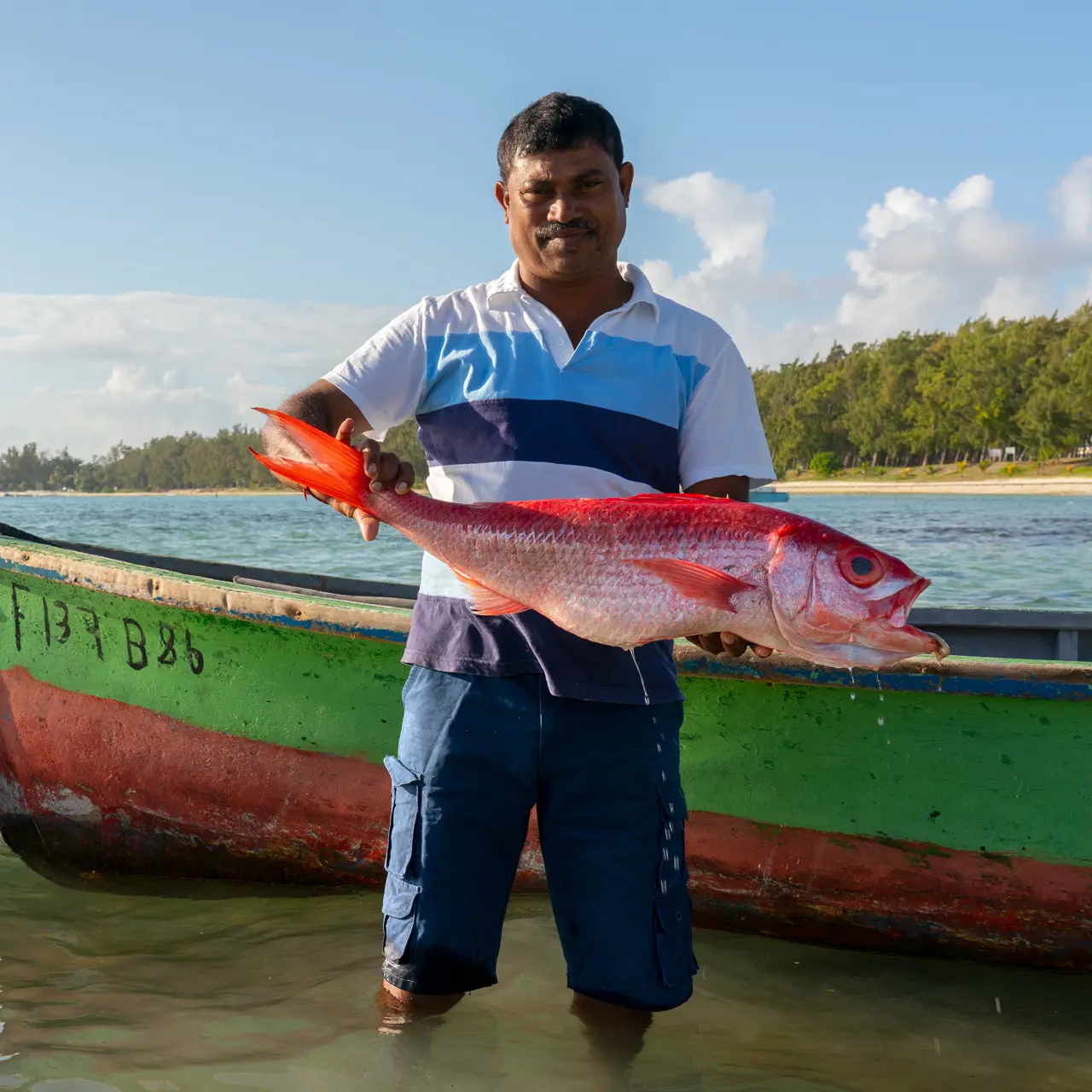 Fisherman Kishor proudly holding his fresh catch.