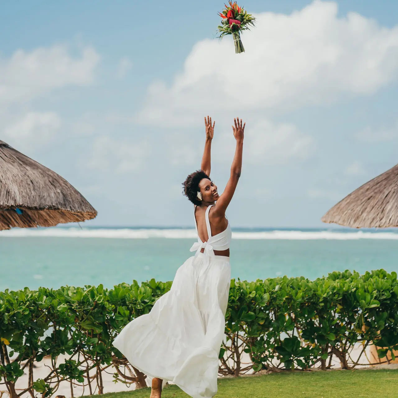 Mariée lançant son bouquet dans les jardins tropicaux.