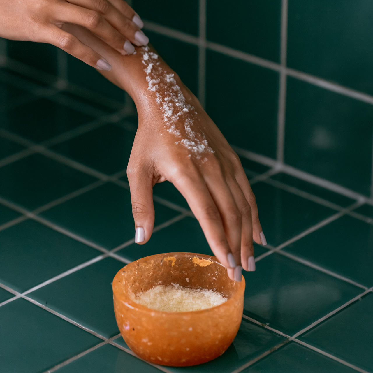 Hand applying a natural salt scrub.
