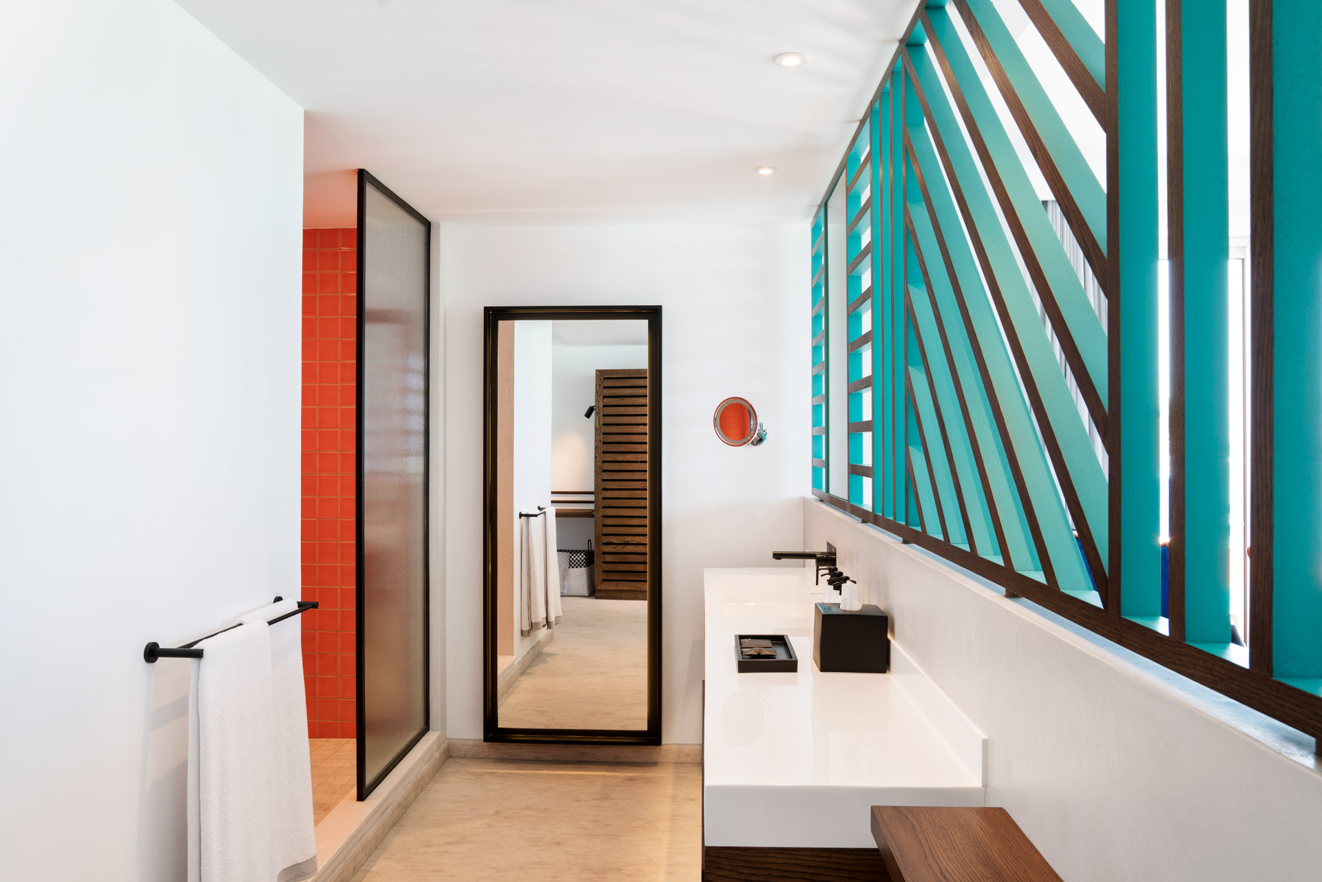 Contemporary hotel bathroom with a spacious vanity, walk-in shower and modern design details.