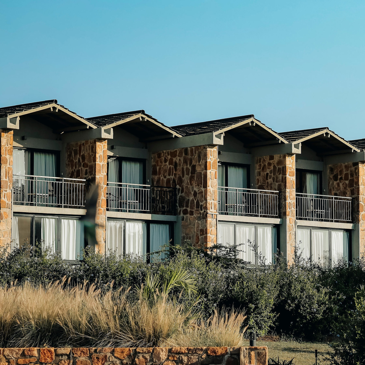Stone-clad guest rooms overlooking the gardens.