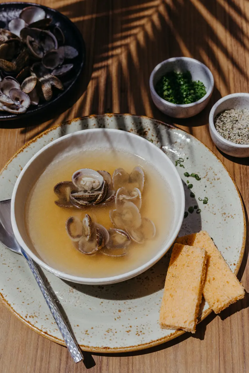 Bouillon de palourdes servi avec du pain grillé.