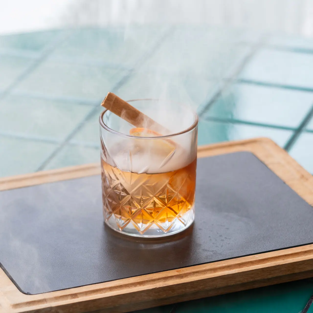Smoked cocktail served with cinnamon and citrus.