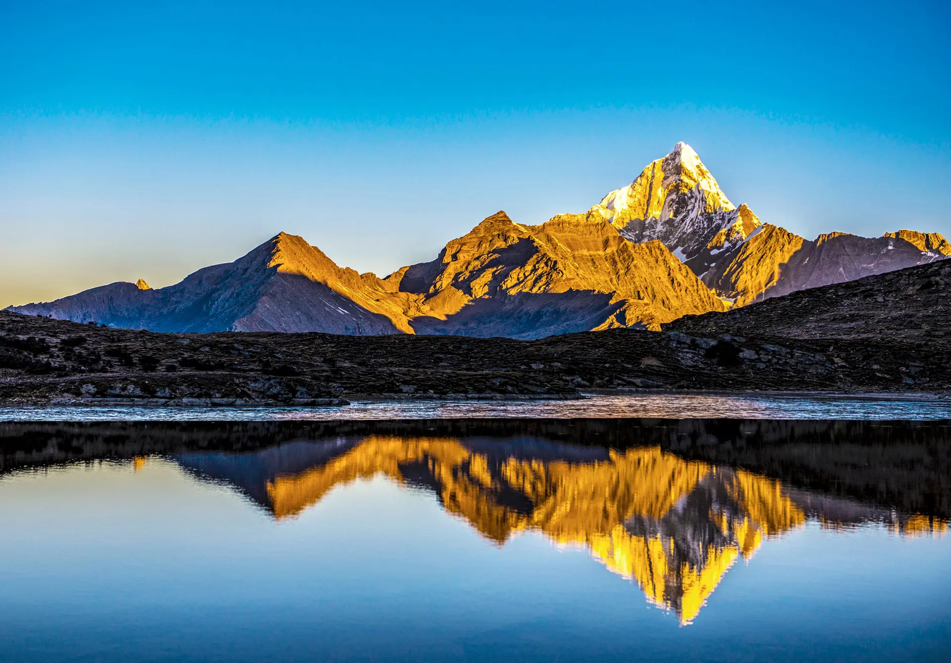 Mountain peaks reflected in a lake near SALT of Mount Siguniang.