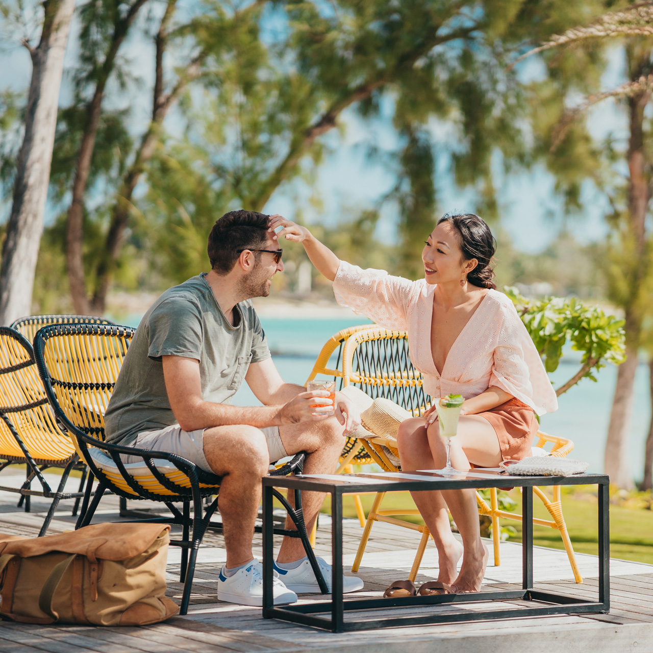 Couple relaxing with cocktails on the terrace overlooking the lagoon.