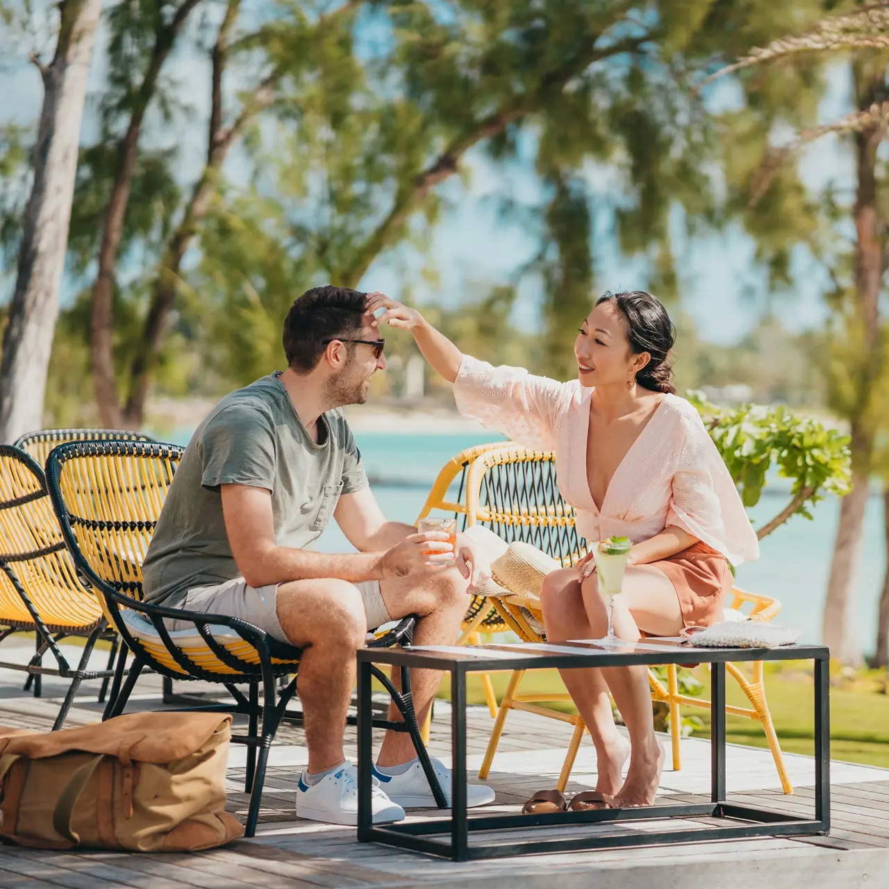 Couple relaxing with cocktails on the terrace overlooking the lagoon.
