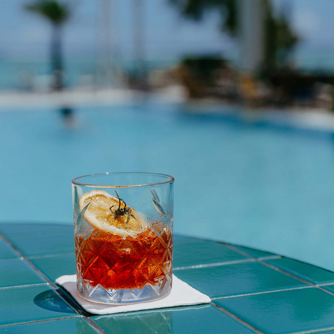 Cocktail signature No Smoke Without Fire au bord de la piscine.