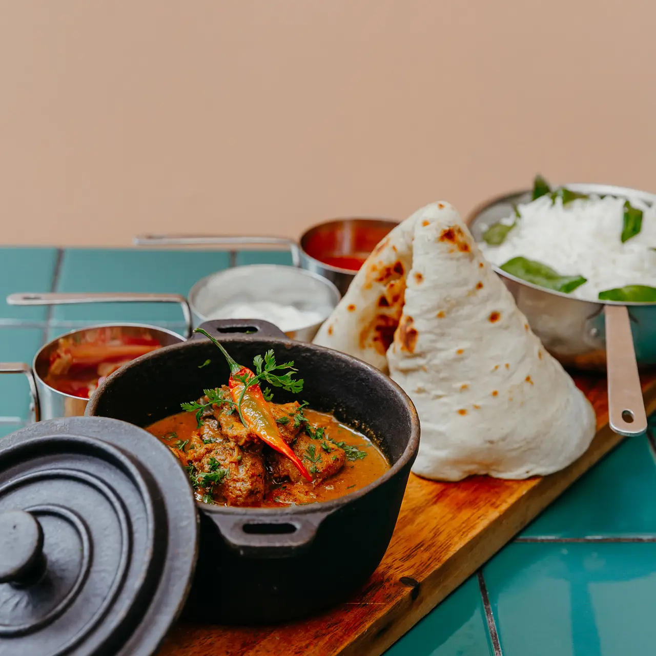 Traditional Mauritian chicken curry served with naan, rice and chutneys.
