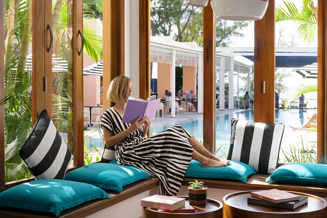 The Library avec ses coins lecture confortables donnant sur la piscine et les jardins tropicaux.