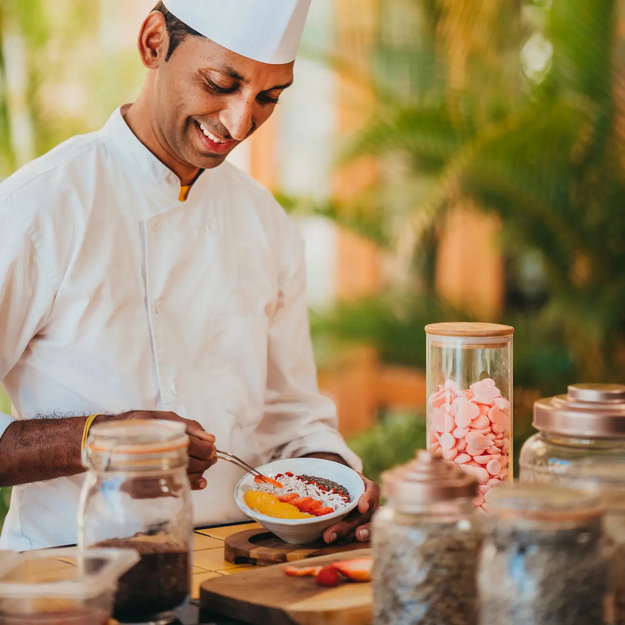 Chef preparing a raw fruit breakfast bowl.
