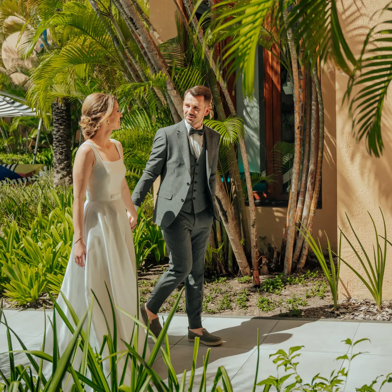 Newlyweds walking through the tropical gardens.