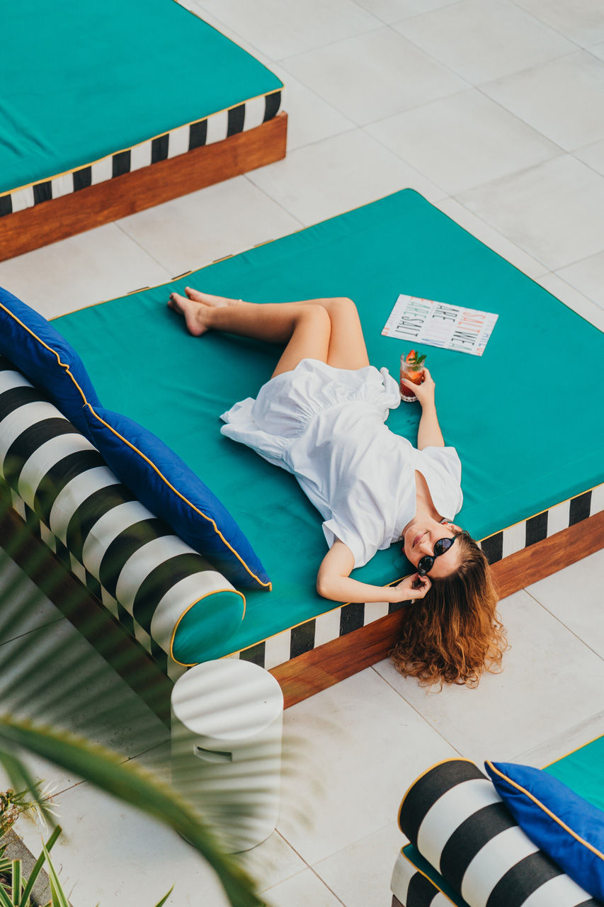Moment de détente avec un verre sur un transat au bord de la piscine.