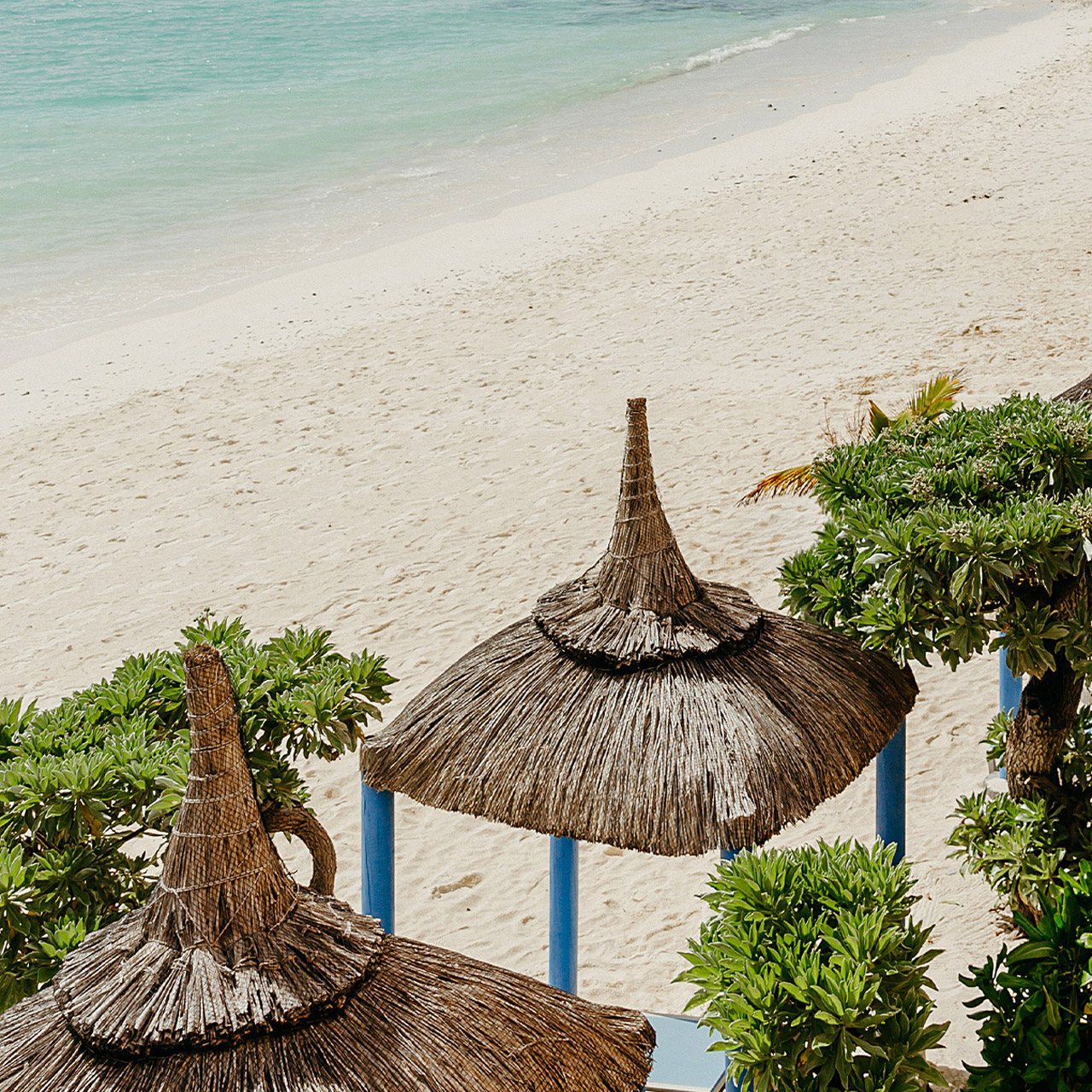 Thatched beach umbrellas overlooking the white sandy beach.
