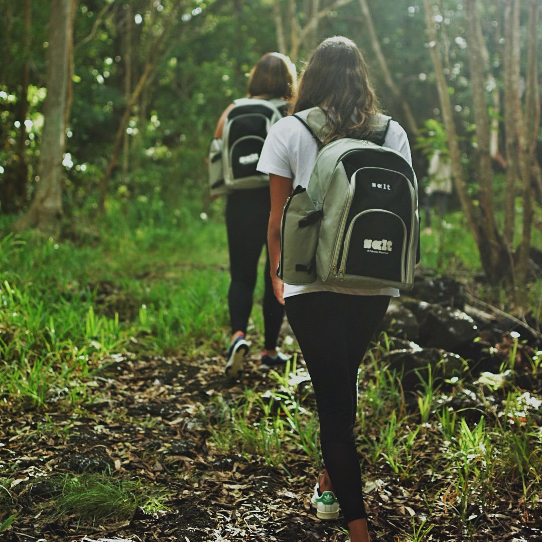 Guests on a forest walk with SALT picnic backpacks.