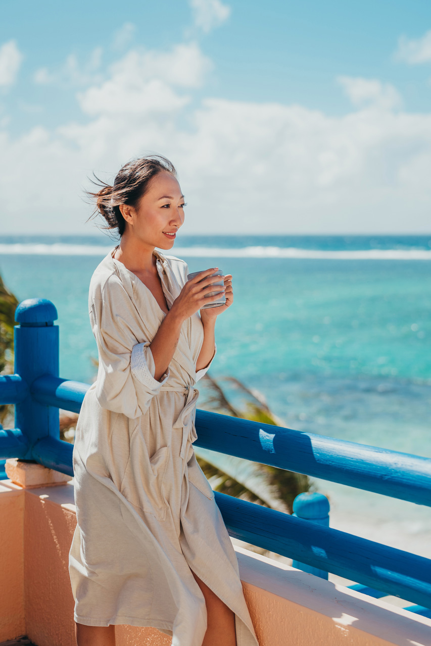 Guest enjoying a coffee on a balcony overlooking the lagoon.
