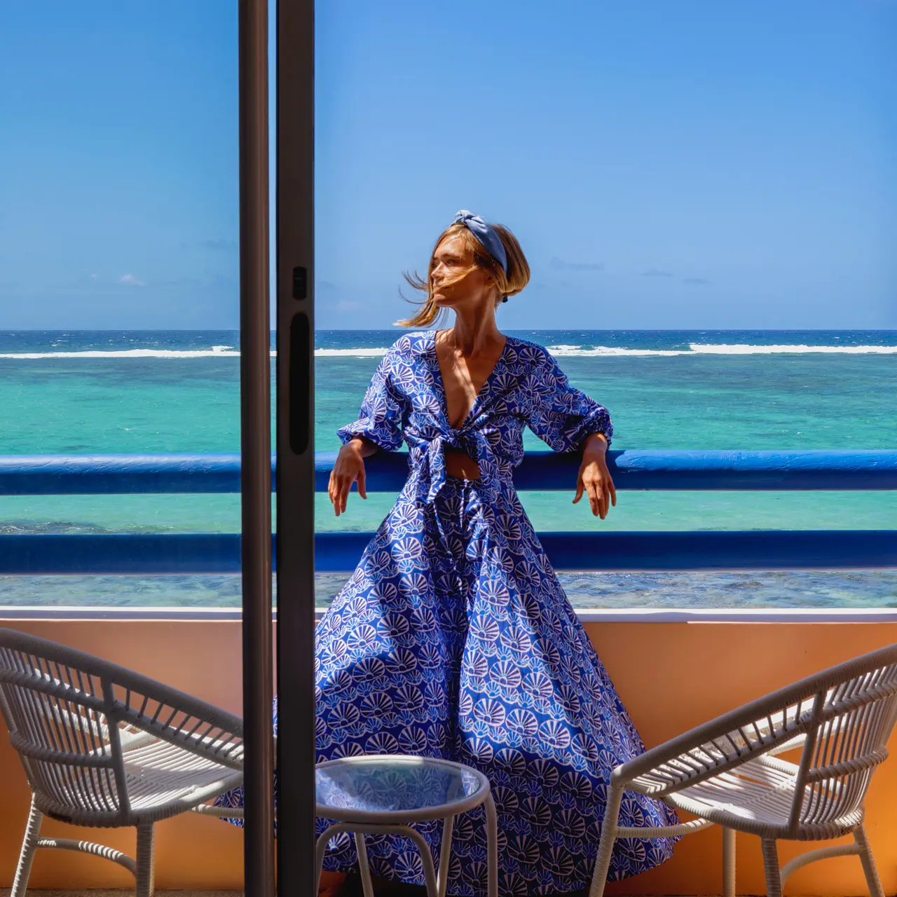 Guest on a balcony overlooking the turquoise ocean at SALT of Palmar.