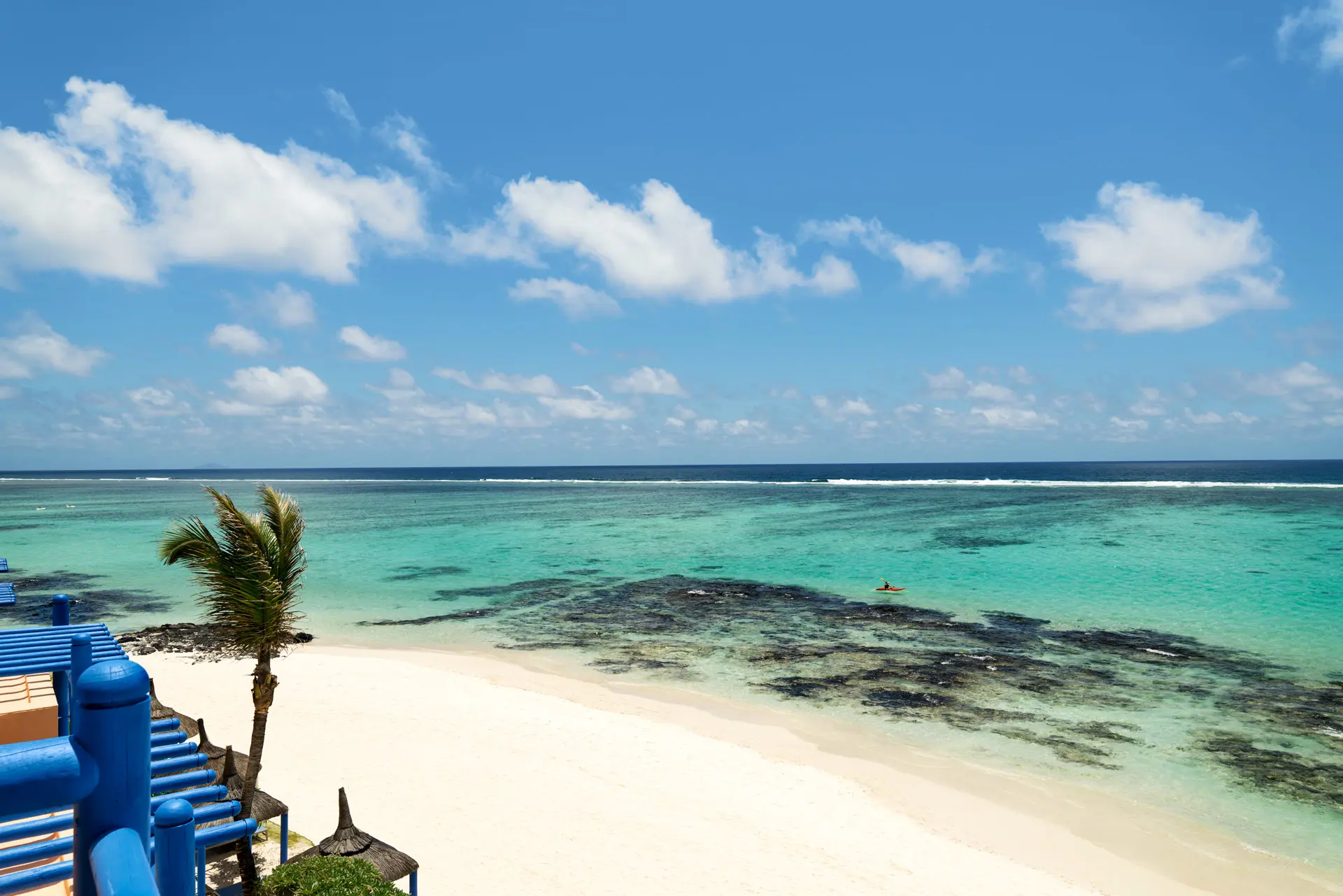 Panoramic ocean view from the hotel overlooking a white sandy beach and turquoise lagoon.