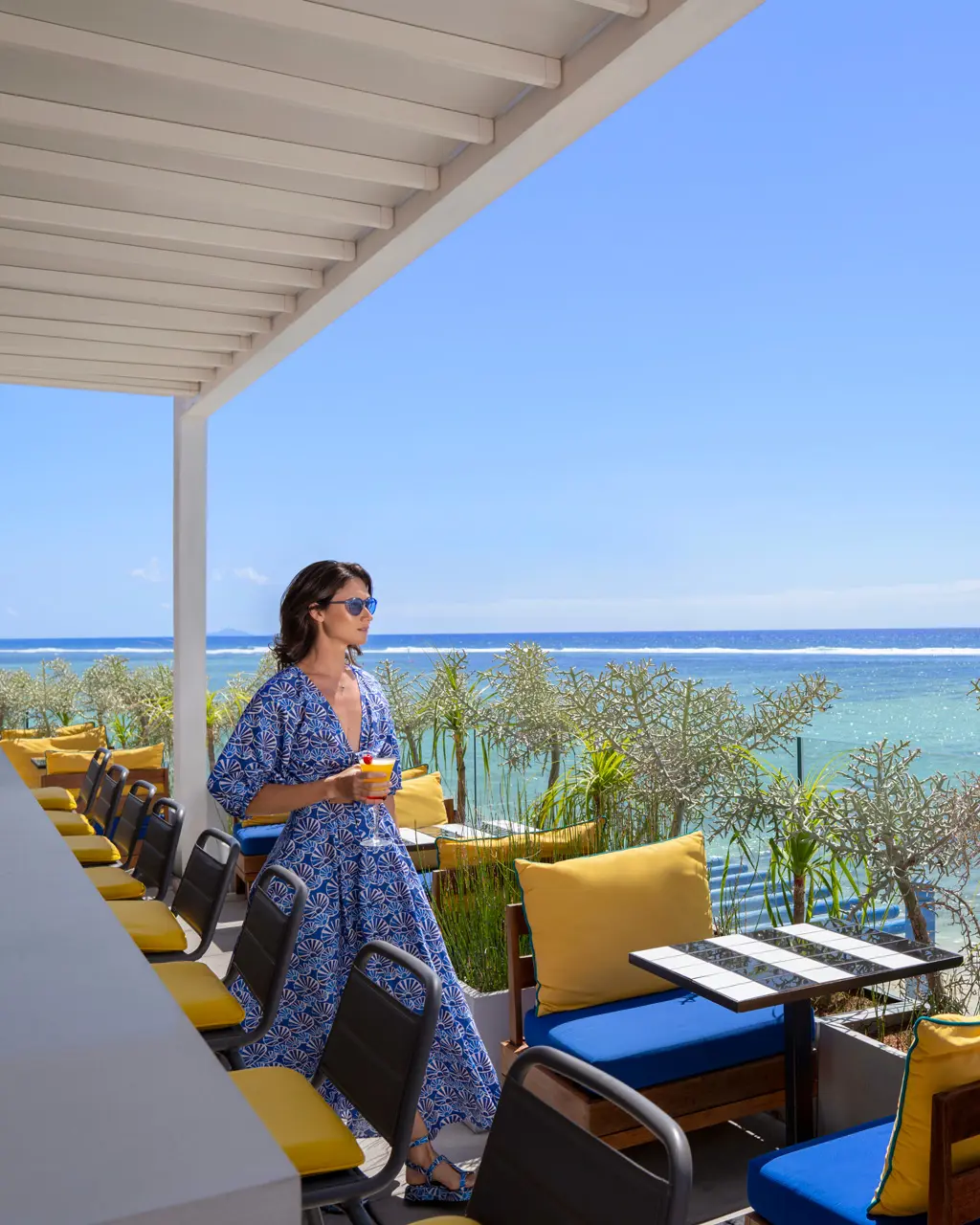 Cliente savourant un cocktail sur la terrasse du rooftop.