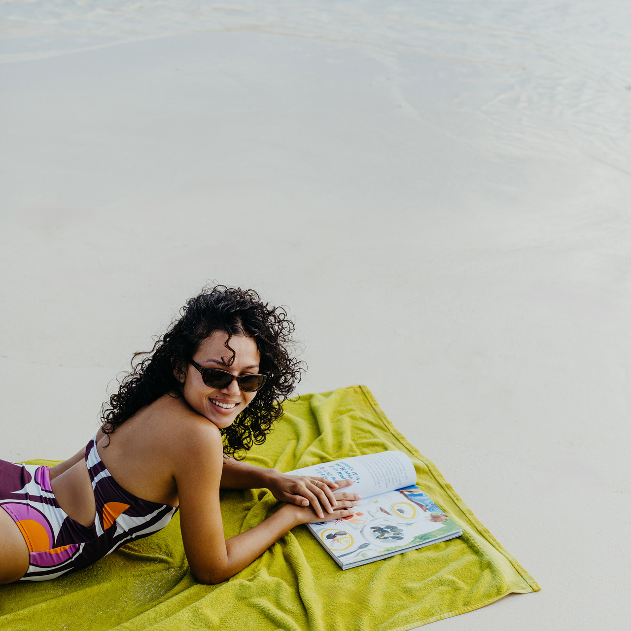 Guest relaxing on the beach with a book at SALT of Palmar.