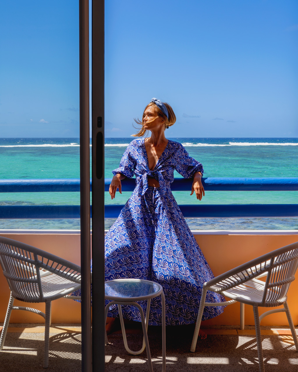 Moment de détente sur un balcon avec vue sur l’océan turquoise.