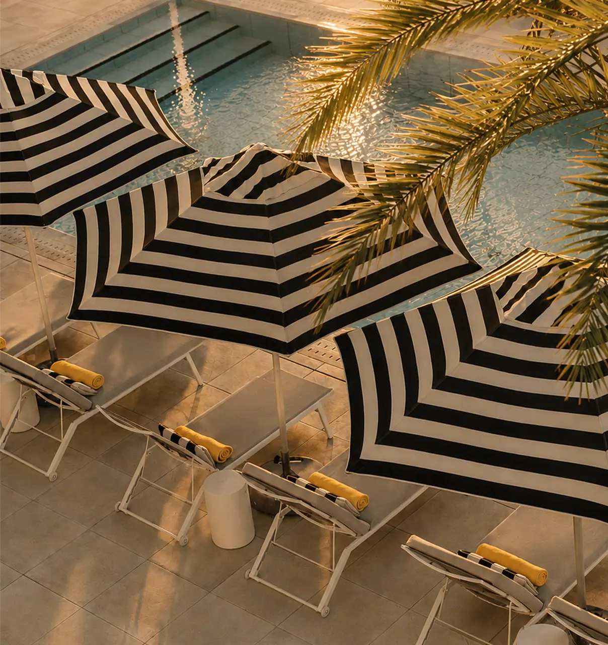 Poolside loungers and striped umbrellas at SALT of Palmar.